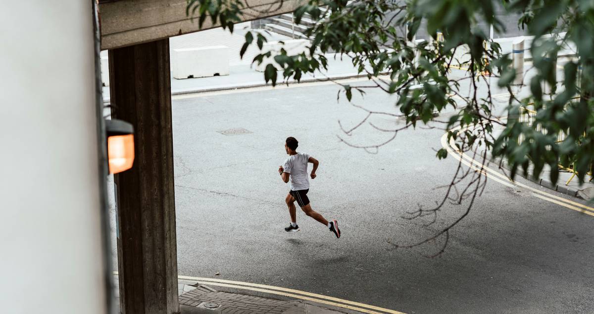 running training program for beginners showing a person walking and jogging on a quiet neighborhood street at sunrise