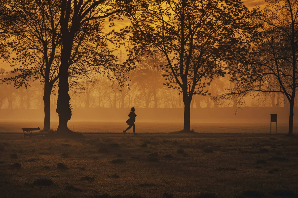 tips to start running beginners: woman jogging slowly on a quiet neighborhood street with proper form and supportive sneakers